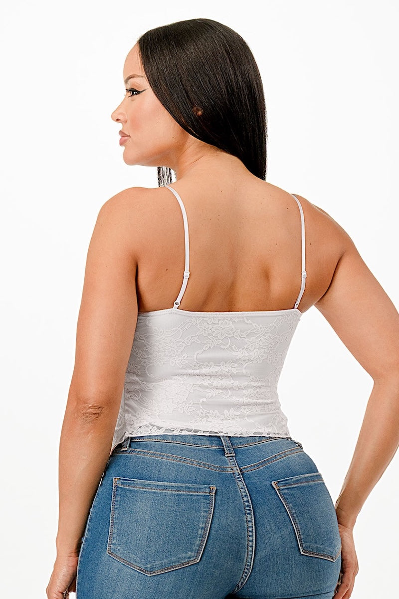 Woman wearing a white tank top and blue jeans on a white background