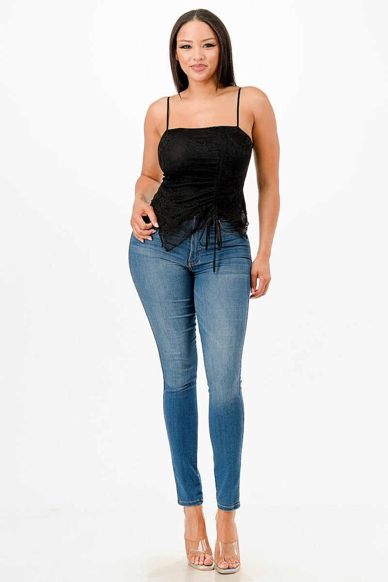 Woman wearing a black top and blue jeans on a white background