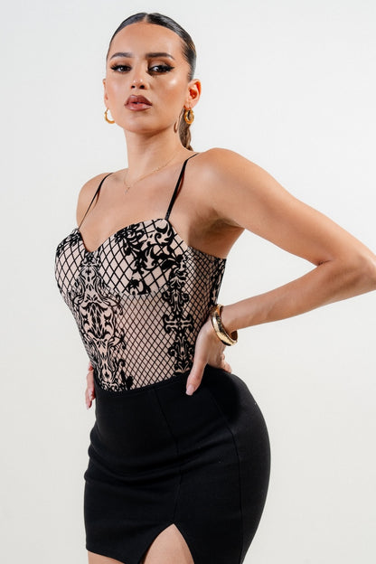 Woman wearing a black velvet bodysuit with a white background