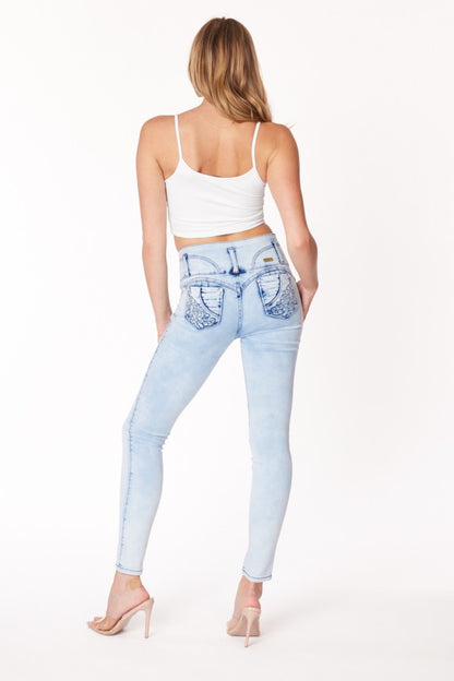 Woman wearing light blue jeans with decorative stitching on a white background