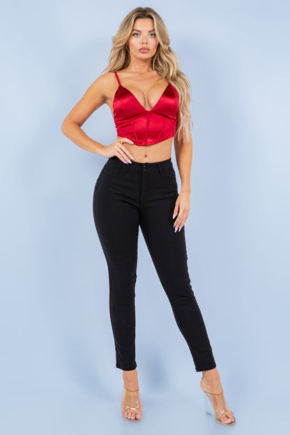 Woman wearing a red top and black pants against a light blue background
