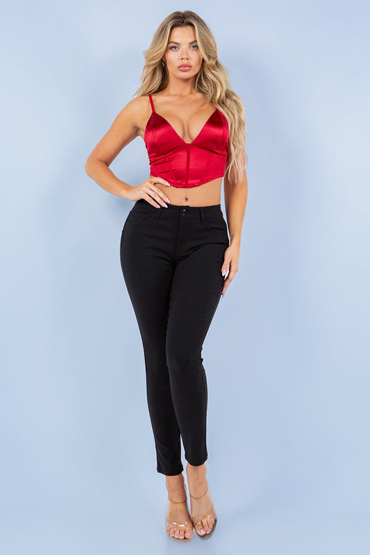 Woman wearing a red top and black pants against a light blue background