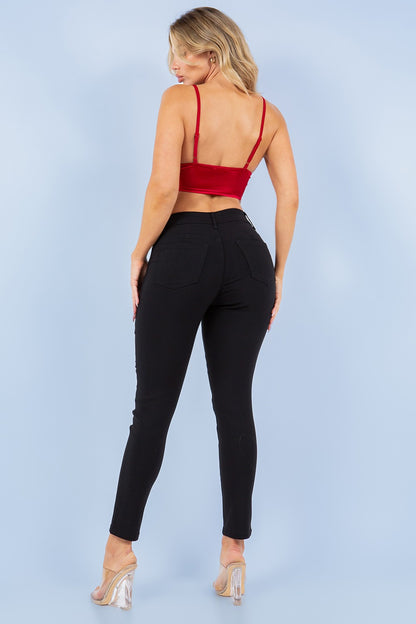Woman wearing a red top and black pants against a light blue background