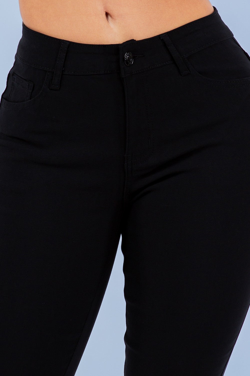 Black pants on a person against a light blue background
