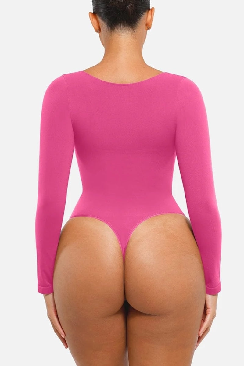 Person wearing a bright pink bodysuit on a white background