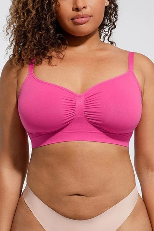 Woman wearing a fuchsia bralette and beige underwear against a neutral background