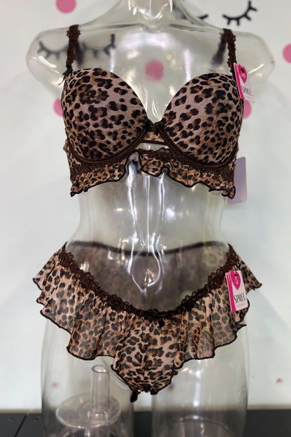 A leopard print lingerie set with ruffle trim displayed on a clear mannequin torso. The set includes a bra and matching high-waisted briefs in a brown and beige animal print pattern with dark brown lace trim.