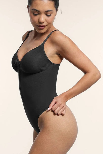 Woman wearing a black bodysuit against a beige background