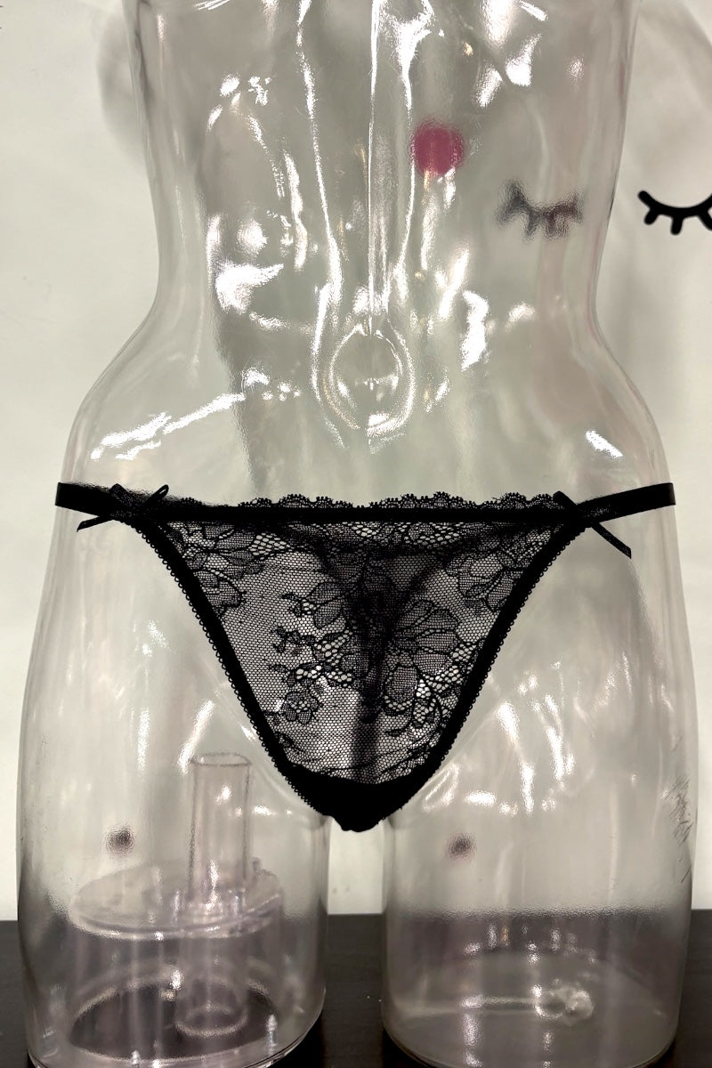 Black lace thong underwear displayed on a clear plastic female mannequin torso against a light background.