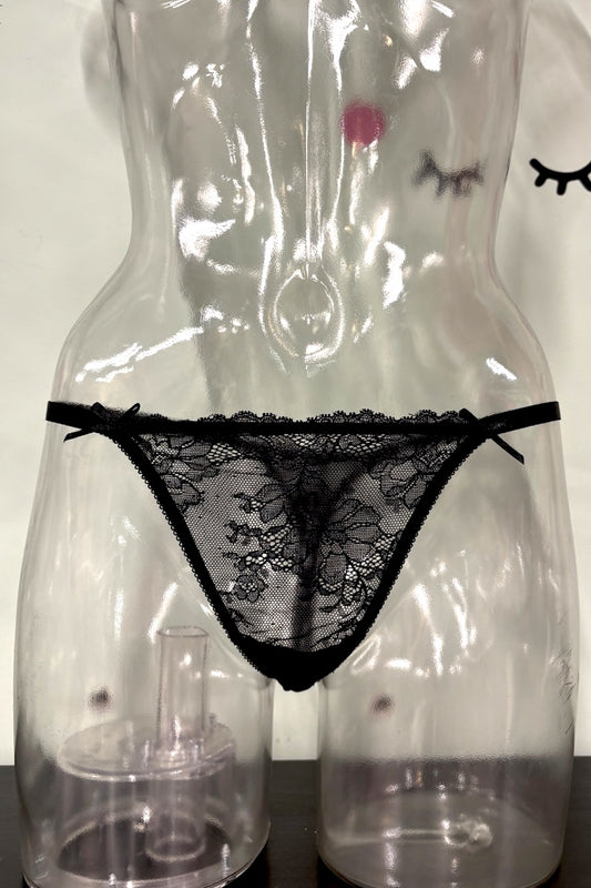 Black lace thong underwear displayed on a clear plastic female mannequin torso against a light background.