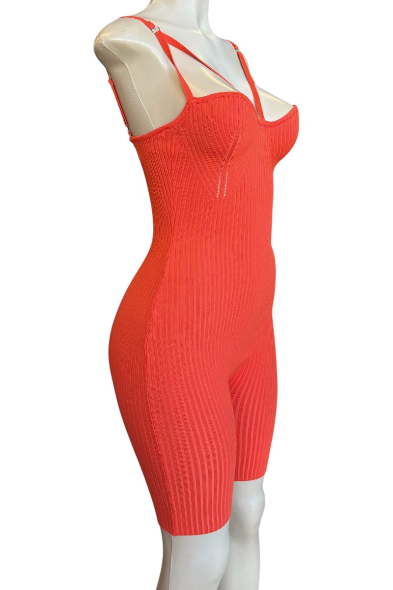 A bright coral-red ribbed knit one-piece jumpsuit displayed on a white mannequin against a plain white background.