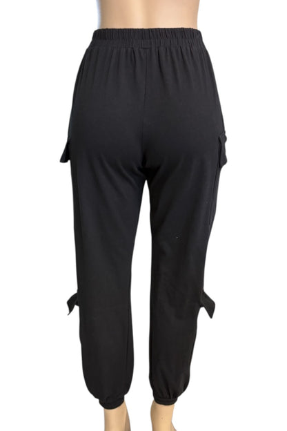 Black cargo jogger pants with side flap pockets and tie details at the ankles, shown from the back on a mannequin against a white background.