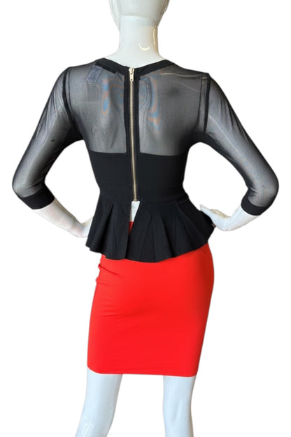 Mannequin wearing a black top with sheer sleeves and red skirt on a white background