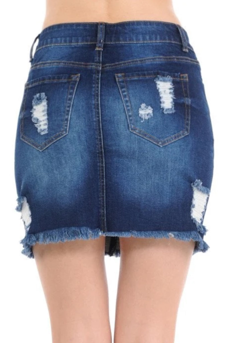Ripped blue denim mini skirt with distressed details and frayed hem, shown on a model from the back.