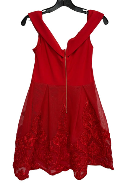Red dress with lace details on a hanger against a white background