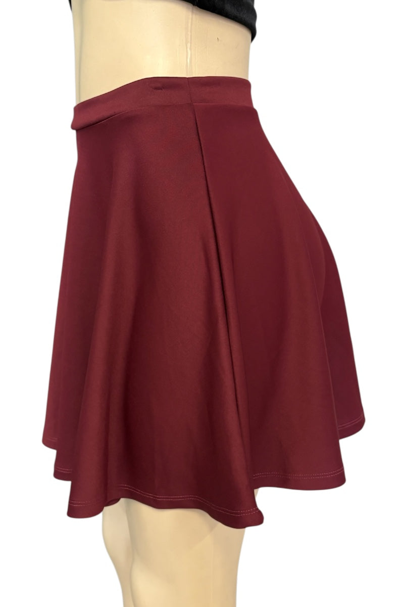 A red flared mini skirt displayed on a beige mannequin torso against a plain white background.