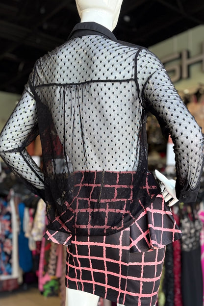 Mannequin wearing a black top and checkered skirt in a store setting