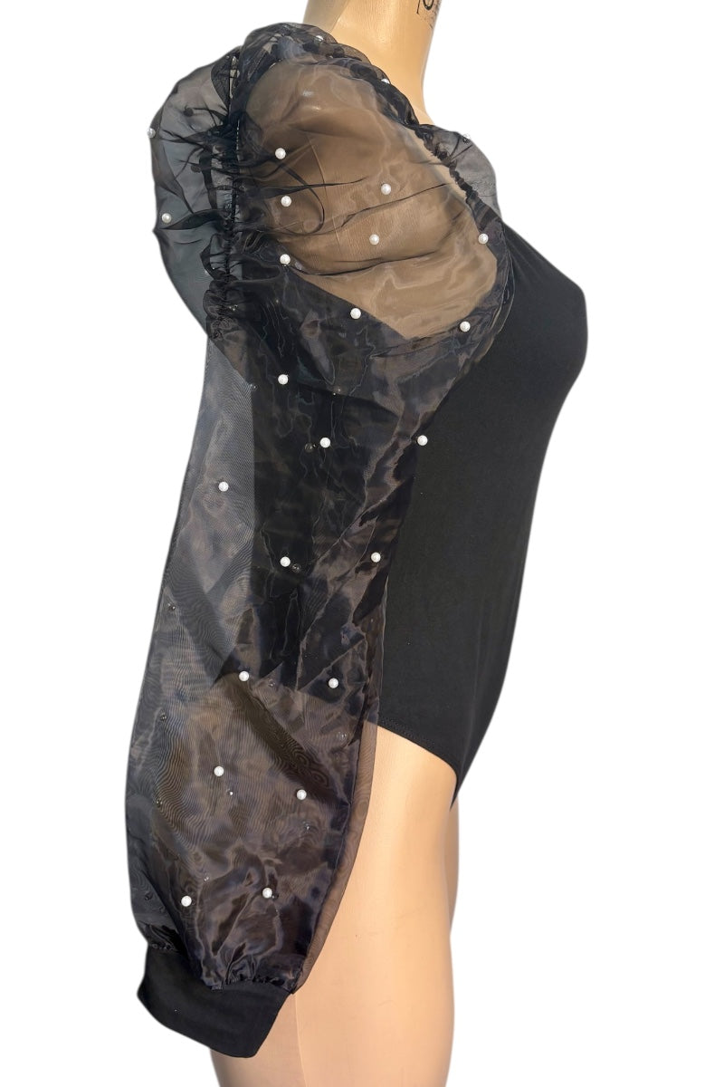 Black sheer top with pearl embellishments on a mannequin against a white background