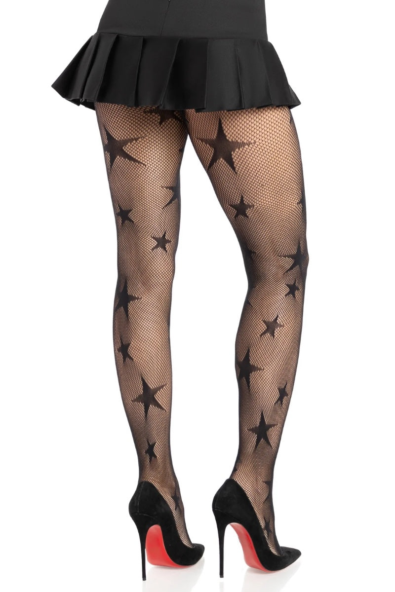 Black fishnet tights with a star pattern, shown on a model from the back wearing a black pleated mini skirt and black high heels with red soles.