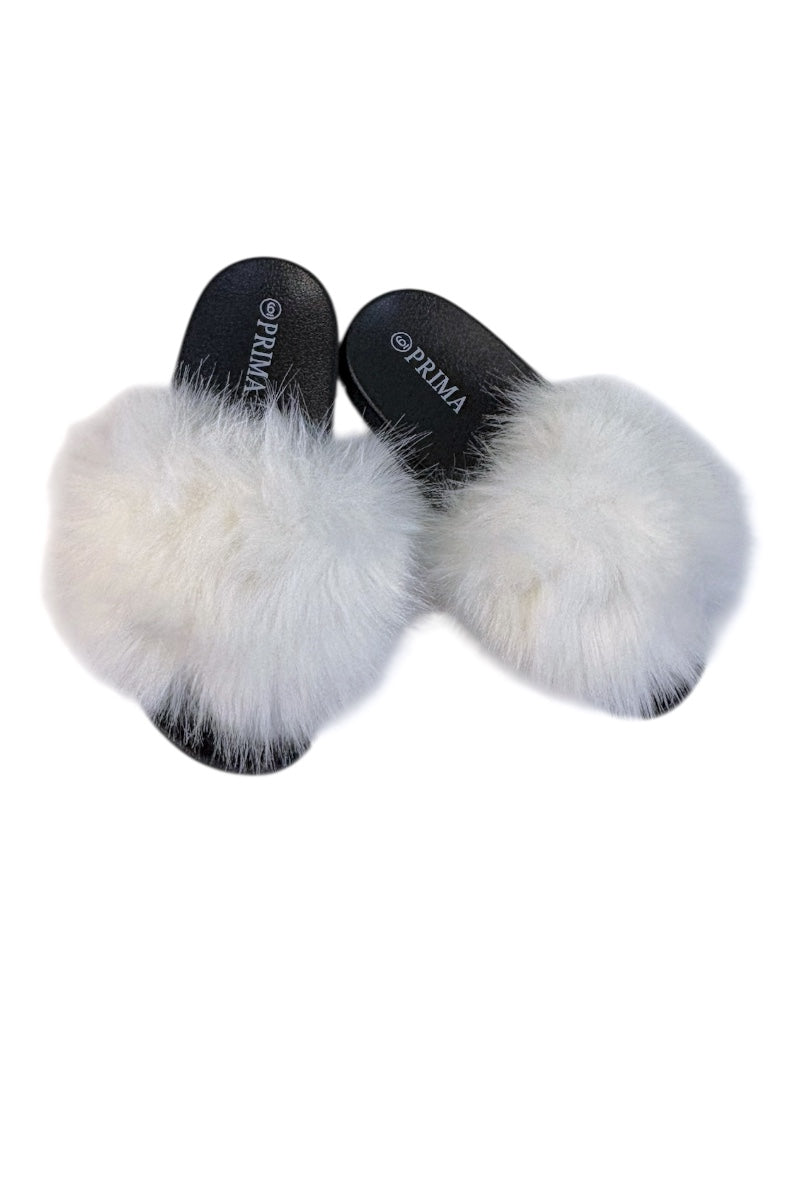 A pair of black slide sandals with fluffy white faux fur trim, shown from a top-down view on a plain white background. The brand name 'PRIMA' is visible on the insole of both sandals.