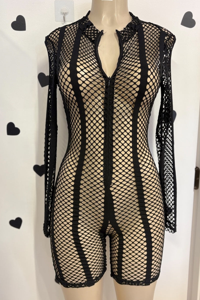 Black fishnet romper with long sleeves and a split neckline, displayed on a mannequin against a white wall with black heart decals.