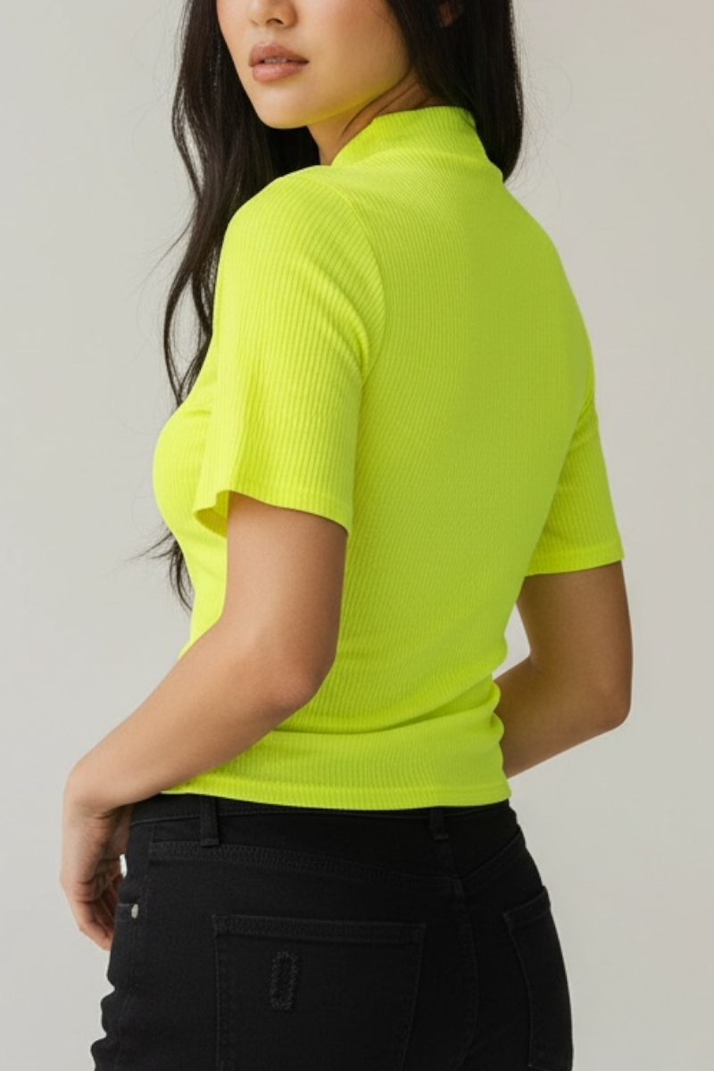Person wearing a bright yellow-green ribbed knit top against a plain background
