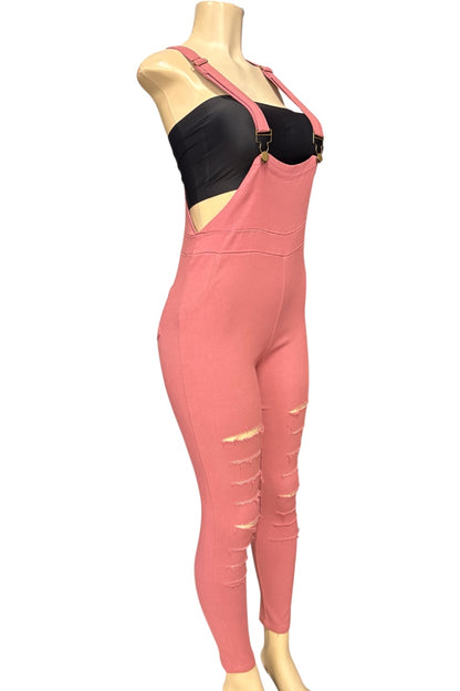 A pink full-length jumpsuit with distressed ripped details on the legs, displayed on a mannequin torso over a black bandeau top against a white background.