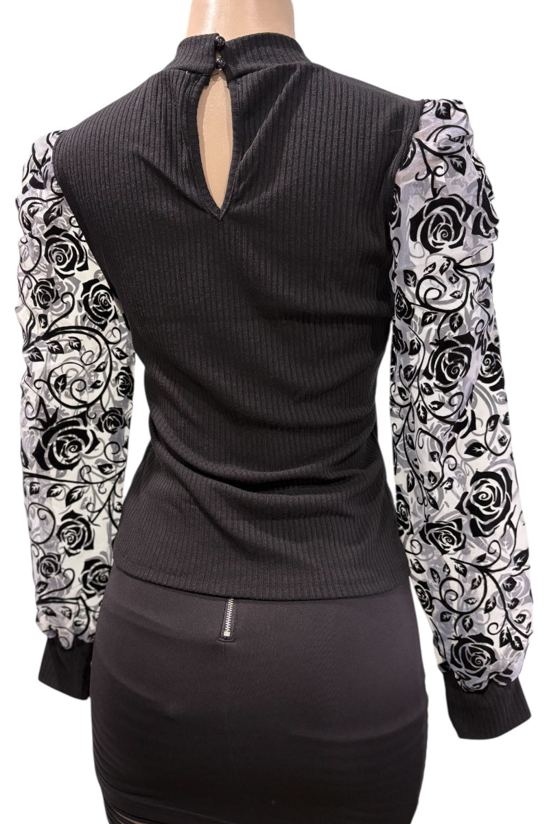 Black ribbed top with floral patterned sleeves on a mannequin against a white background