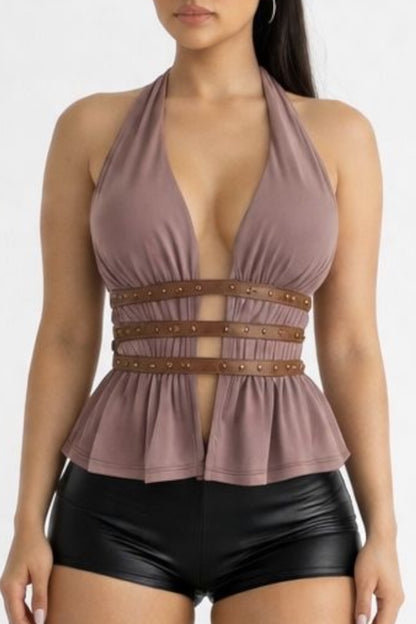 Woman wearing a brown peplum top with brown belt and black shorts on a white background