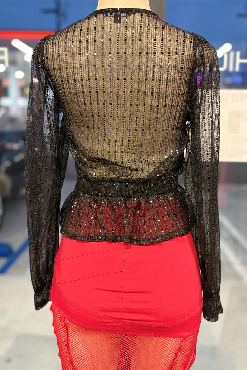 Mannequin wearing a black sequined top and red skirt with a blurred background