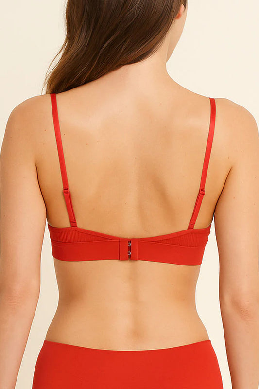 Red bikini top worn by a person on a beige background
