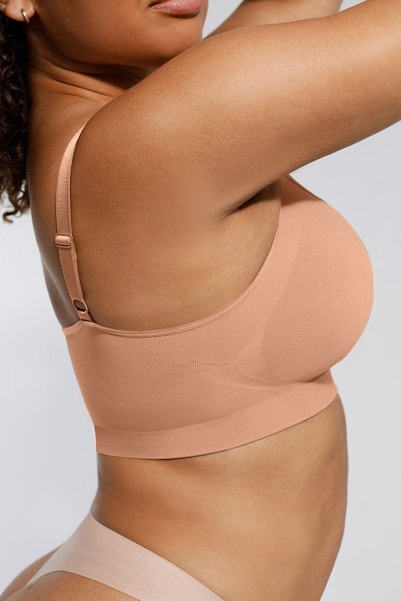 Person wearing a beige bralette on a plain background