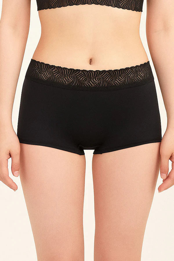 Black underwear with lace waistband on a beige background
