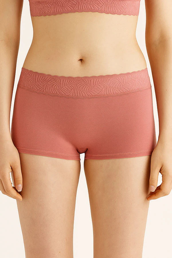 Person wearing pink MauveGlow patterned underwear on a plain background