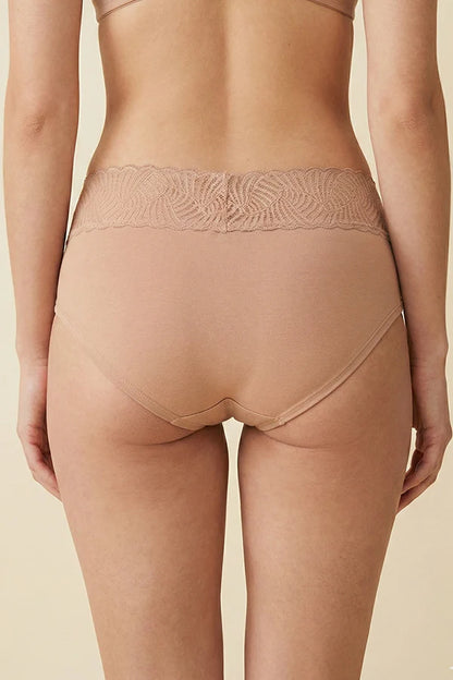 Nude-colored underwear with lace waistband on a beige background