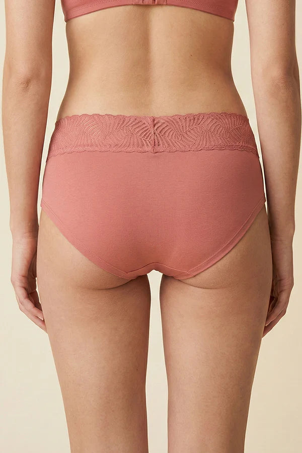 Person wearing a pink MauveGlow high-waisted underwear on a beige background