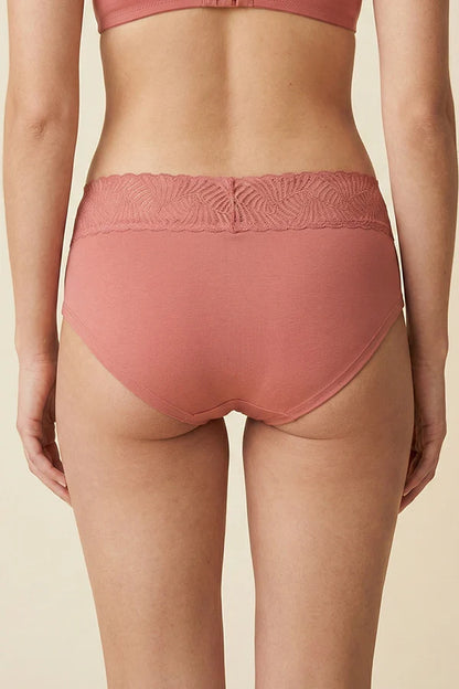 Person wearing a pink MauveGlow high-waisted underwear on a beige background