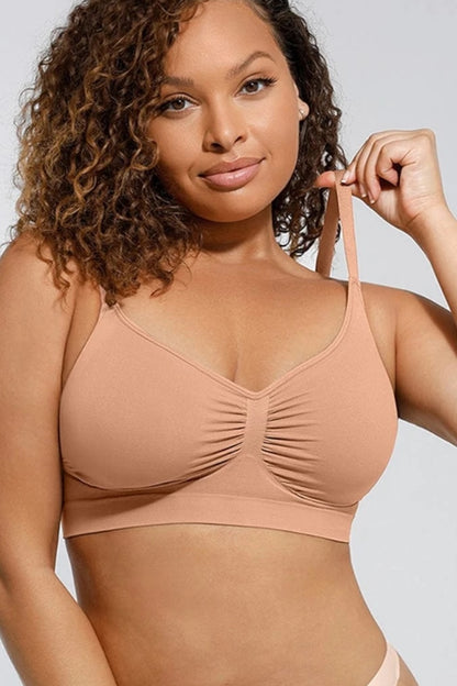 Woman wearing a beige bralette against a plain background