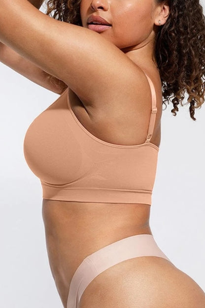 Woman wearing a beige full-coverage bralette and underwear set on a white background