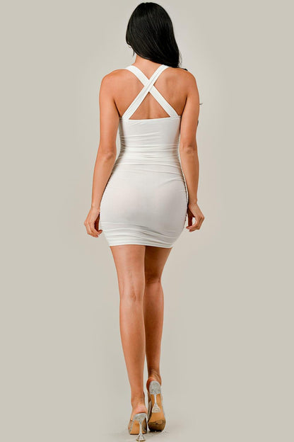 White dress with criss-cross straps worn by a person on a plain background