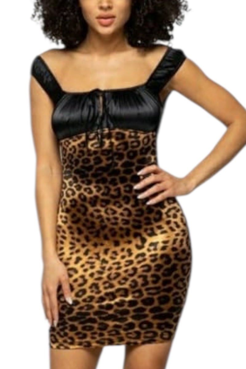 Woman wearing a leopard print dress with black accents on a white background