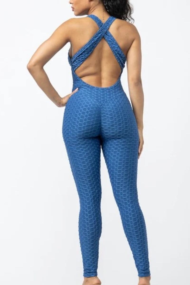 Woman wearing a blue patterned jumpsuit on a white background