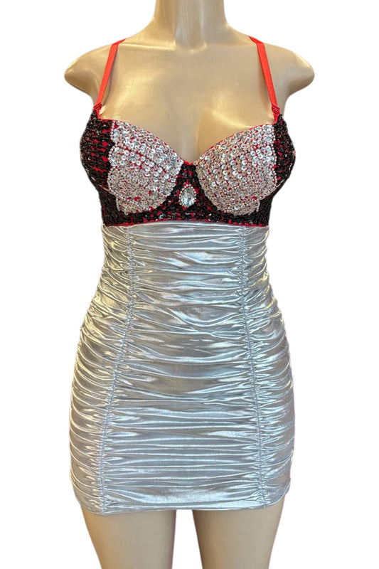 Mannequin wearing a silver dress with a black and red embellished top on a white background