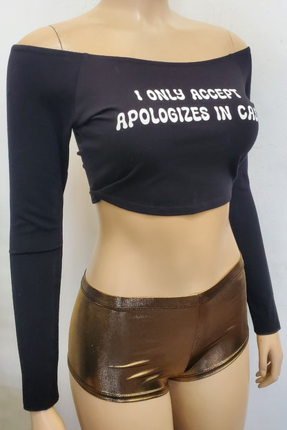Mannequin wearing a black long-sleeve crop top with text and gold shorts on a white background