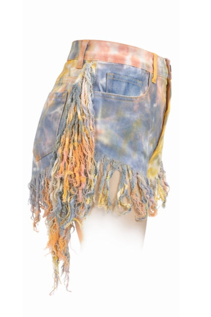 Tie-dye denim shorts with frayed edges on a white background