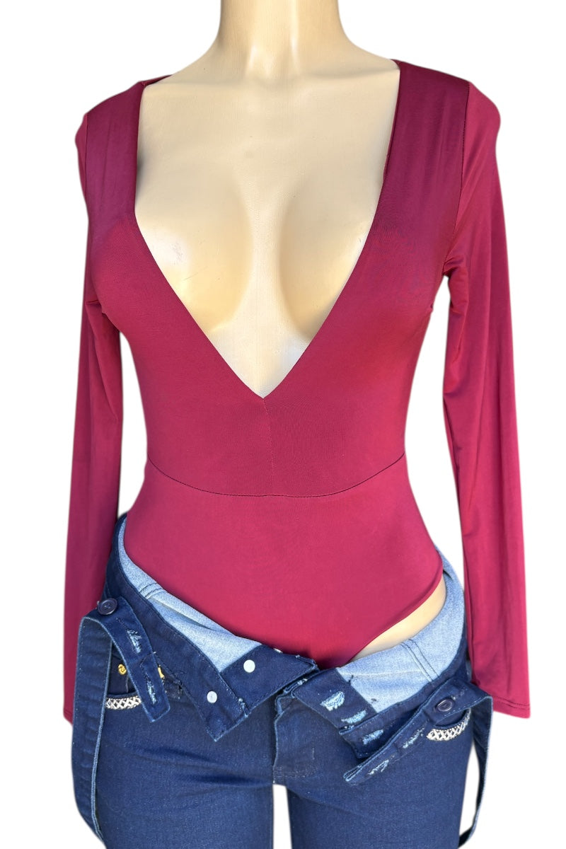 Mannequin wearing a burgundy long-sleeve top with a deep neckline and blue bottoms.