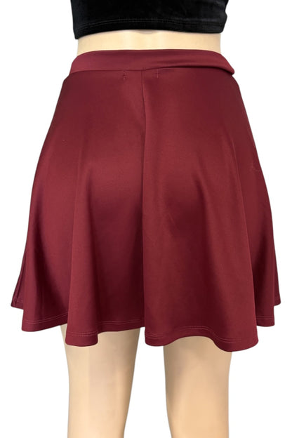 A red flared mini skirt shown from the back on a mannequin, paired with a black crop top against a plain white background.