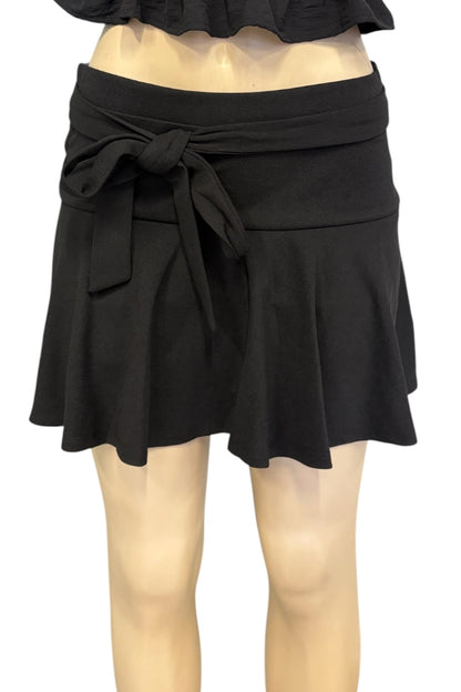 A black wrap-style mini skirt with a tied waist and flared ruffled hem, shown on a mannequin against a plain white background.