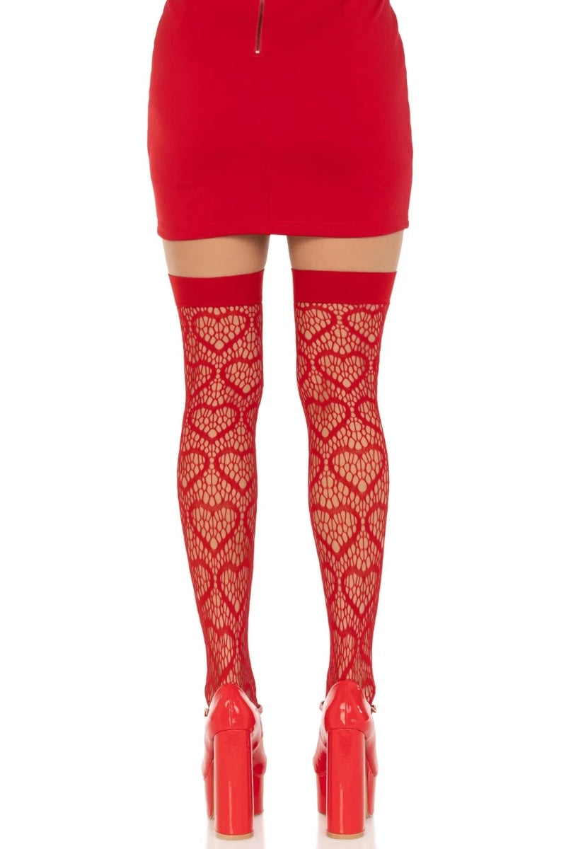 Red thigh-high lace tights with a heart pattern worn with a red mini skirt and red platform heels, shown from the back on a white background.