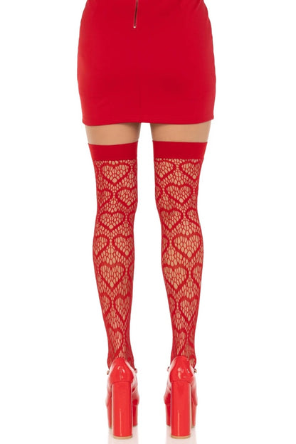 Red thigh-high lace tights with a heart pattern worn with a red mini skirt and red platform heels, shown from the back on a white background.